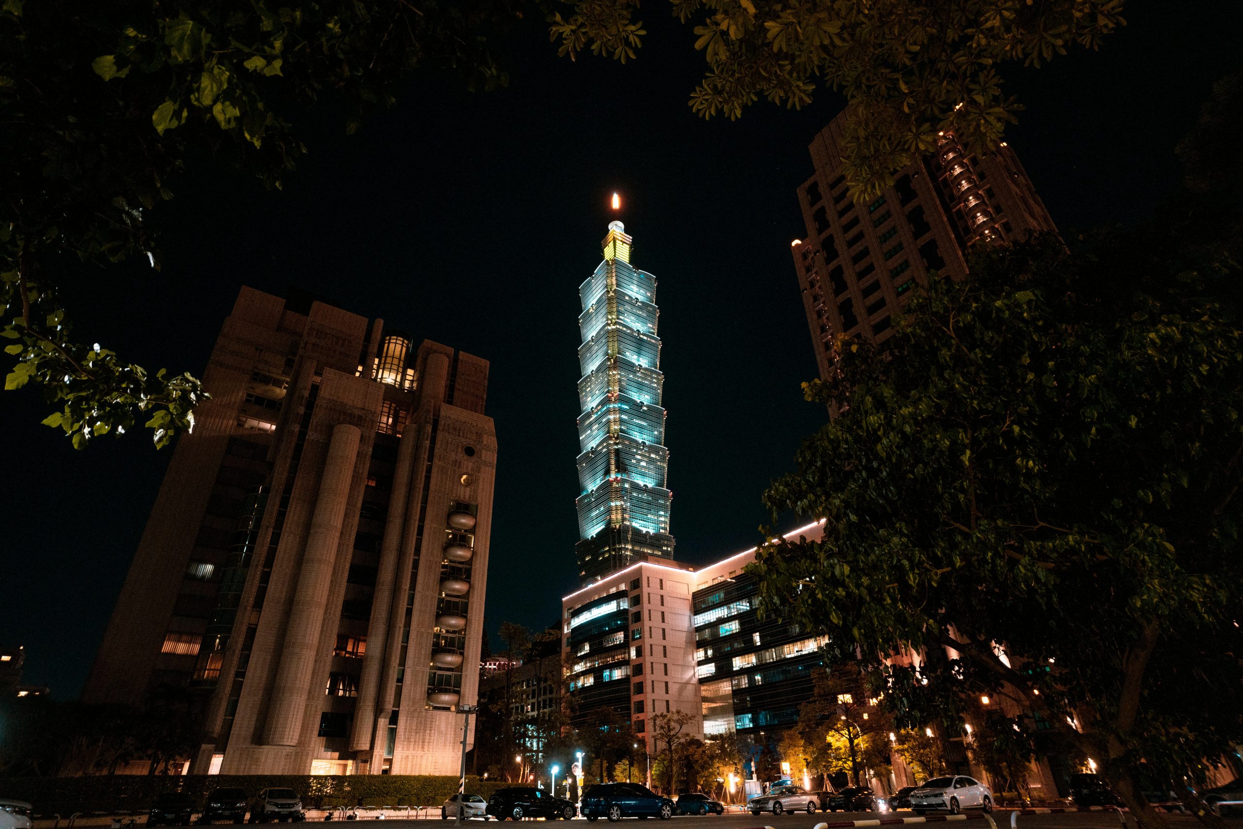 Nighttime cityscape featuring the iconic Taipei 101 illuminated against a dark sky.
